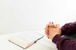 a person sitting at a table with an open book